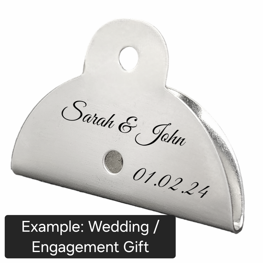 stainless steel dog whitle with engraved text on a white background