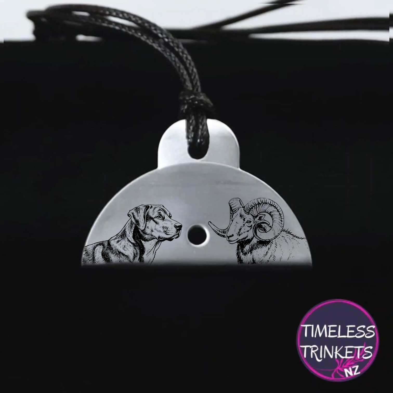 Stainless Steel whistle pendant with engraved dog and ram design on a black background.
