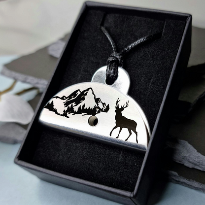 Stainless steel shepherds whistle
pendant with deer and mountain design in a black box