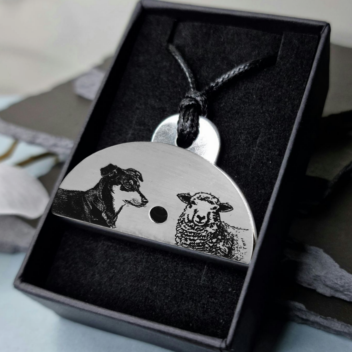 Stainless steel shepherds whistle
with engraved images of a huntaway dog and a sheep in a black gift box.