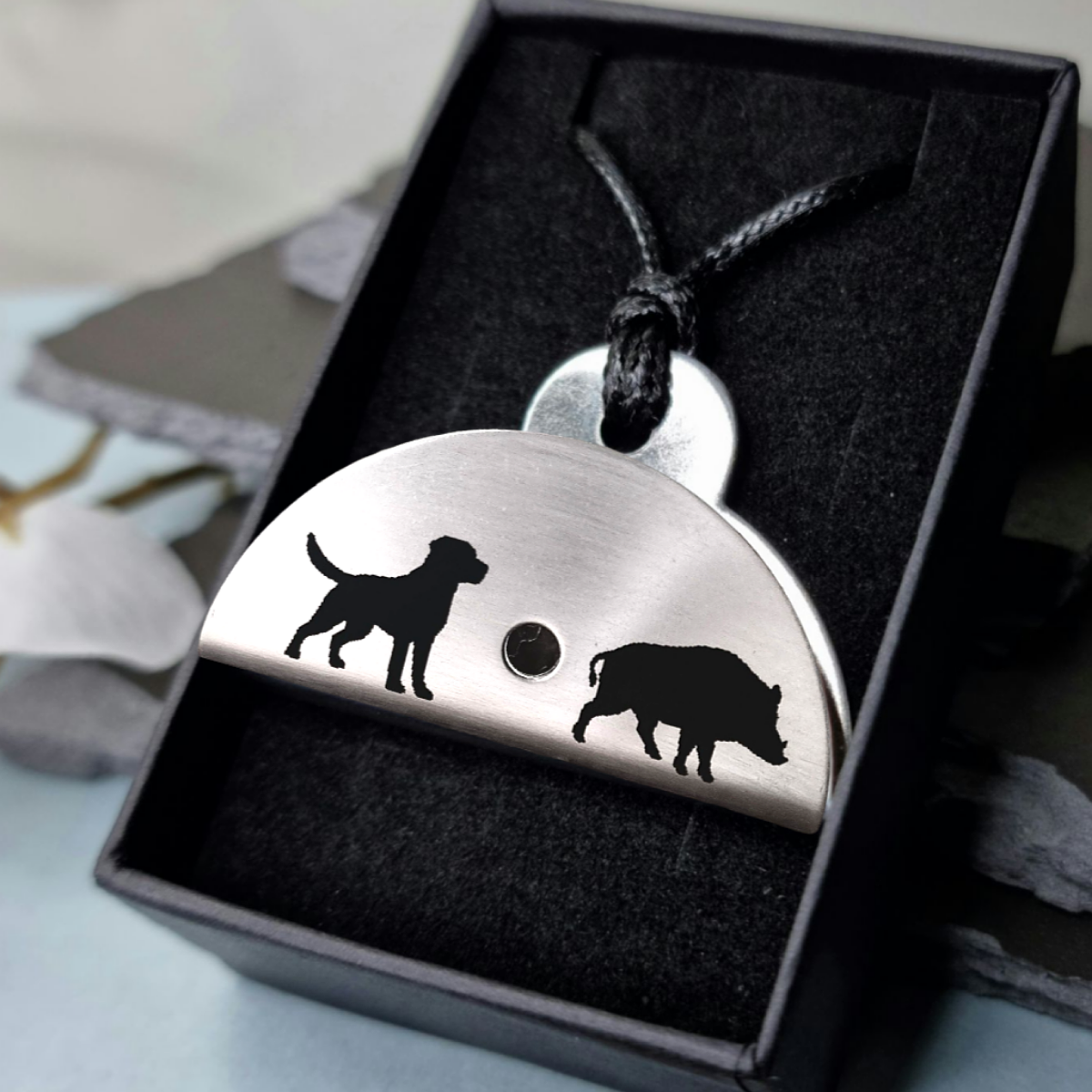 Stainless steel shepherds whistle
pendant with dog and boar silhouettes in a black box