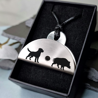 Stainless steel shepherds whistle
pendant with dog and boar silhouettes in a black box